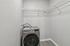 Laundry closet with washer and dryer and overhead shelving