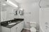Bathroom with single-sink vanity, mirror, and tub-shower combination