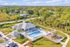Vibrant aerial view of a modern residential neighborhood with pristine homes, scenic landscaping, and a serene lake backdrop.