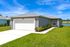 Charming single-story home with modern gray exterior, two-car garage, and lush green lawn, surrounded by picturesque views of a serene lake under a vibrant blue sky.