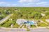 Lush community aerial view showcasing a charming clubhouse, inviting pool, and serene green surroundings.