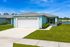 Charming single-story home with a double garage, elegant landscaping, and a bright blue sky backdrop.