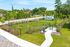Beautiful outdoor space with lush greenery, fenced area, and scenic walking path, perfect for relaxation and outdoor activities.