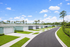 Charming suburban street with modern homes, lush lawns, and bright blue skies, perfect for family living.