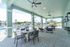 Chic covered patio with cozy seating overlooking a refreshing pool, set against a backdrop of lush greenery.