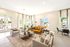 Bright and inviting living room with plush seating, stylish decor, and large windows offering a scenic view.