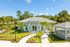 Charming residence with a welcoming entrance, lush landscaping, and elegant architecture, surrounded by tranquil greenery.