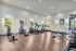 Bright, modern gym with state-of-the-art cardio and strength equipment, large windows, and sleek wood flooring.