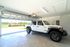 Spacious garage with a sleek, parked SUV, offering convenience and scenic views of greenery through the open door.