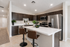 Modern kitchen with sleek dark cabinets, stainless steel appliances, and a stylish breakfast bar with leather stools.