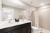 Elegant and modern bathroom featuring a dual-sink vanity, stylish decor, and a spacious walk-in shower.