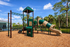 Vibrant playground with a slide and climbing structure set in a lush, sunny setting.