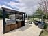 Inviting outdoor area featuring a modern barbecue grill and a cozy seating space under a stylish pergola, perfect for entertaining and relaxation.