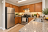 Modern kitchen with elegant wood cabinetry, stainless steel appliances, and granite countertops, accented with vibrant greenery and natural lighting.