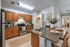 Modern kitchen with elegant granite countertops, warm wooden cabinetry, and a cozy breakfast bar set for dining.