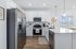 Modern kitchen with sleek stainless steel appliances, elegant white cabinetry, and a spacious island with pendant lighting.