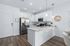 Modern kitchen with sleek white cabinetry, stainless steel appliances, and elegant pendant lighting over a spacious island.