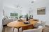 Bright and inviting living room featuring modern decor, cozy seating, and a view of the lush outdoors through large sliding doors.