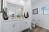 Elegant bathroom with dual sinks, modern fixtures, and bright natural lighting.