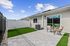 Charming outdoor patio with stylish seating and lush artificial grass, perfect for enjoying sunny days.