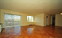Spacious apartment interior with large windows providing abundant natural light, highlighted by elegant wooden parquet flooring.
