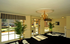 Elegant apartment lobby with bright natural light, stylish chandelier, and lush potted plants creating an inviting atmosphere.