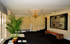 Elegant lobby area with a stylish chandelier, inviting bench seating, lush greenery, and an abundance of natural light.