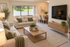 Inviting living room with elegant decor, comfortable beige sofas, and a stylish wooden coffee table, adjacent to a modern dining area with seating for four.