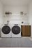 Streamlined laundry room at The Oslo featuring full-size washer and dryer, ample shelving for storage, and a functional layout toStreamlined laundry room at The Oslo featuring full-size washer and dryer, ample shelving for storage, and a functional layout to streamline your daily chores. streamline your daily chores.