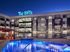 The Lofts at City Center exterior at dusk with illuminated windows" Caption: "Welcome home to modern urban living