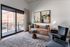 Apartment living room with a sofa and armchairs beside floor-to-ceiling sliding doors that open to a private balcony