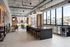 Clubroom with a long black island, bar stools, beverage fridges, globe pendant lights and floor-to-ceiling windows