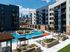 Pool courtyard with shaded cabanas, orange umbrellas and loungers, with the downtown Kansas City skyline beyond