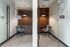 Two glass-enclosed private work studios, each with a desk, task chair and pendant light
