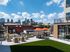Courtyard with a turf lawn, lounge chairs and umbrella-shaded tables overlooking the downtown skyline
