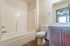 Bright and modern bathroom featuring a white bathtub, sleek sink, and stylish flooring.