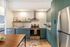 Modern kitchen with sleek green cabinetry, stainless steel appliances, and stylish decor.