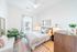 Bright and airy bedroom with modern decor, featuring a cozy bed, stylish lighting, and lush indoor plants creating a tranquil oasis.