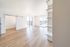 Bright, spacious living room with sleek hardwood floors, large windows offering natural light, and elegant built-in shelving, perfect for modern living.