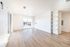 Bright and airy living space with large windows and elegant hardwood floors, featuring built-in shelves for stylish storage.