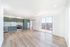 Modern open-concept apartment featuring sleek green cabinetry, stainless steel appliances, and a balcony with natural light.