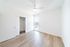 Bright and spacious bedroom with wood flooring, a built-in closet, and a modern ceiling fan, complemented by natural light from a large window.