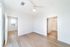 Bright and airy bedroom with elegant hardwood floors and a large window, perfect for natural lighting and modern living.