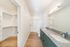 Bright, modern bathroom with elegant granite countertops, double sinks, and a spacious walk-in closet; perfect for a luxurious living experience.