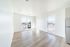 Bright, open living space with large windows and sleek hardwood floors, showcasing a modern, sunlit apartment.