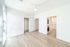 Bright and airy bedroom with built-in shelves, sleek laminate flooring, and in-unit washer and dryer.