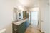 Sleek modern bathroom with dual sinks and granite countertops, featuring built-in laundry units and ample storage space.