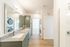 Elegant bathroom featuring a dual-sink granite countertop, modern cabinetry, and built-in laundry appliances in a bright, spacious setting.