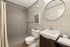 Elegant modern bathroom with stylish tiled walk-in shower, sleek fixtures, and a chic oval mirror enhancing the space.