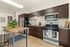 Modern kitchen with sleek dark cabinetry, stainless steel appliances, and a stylish wooden island with bar stools.
